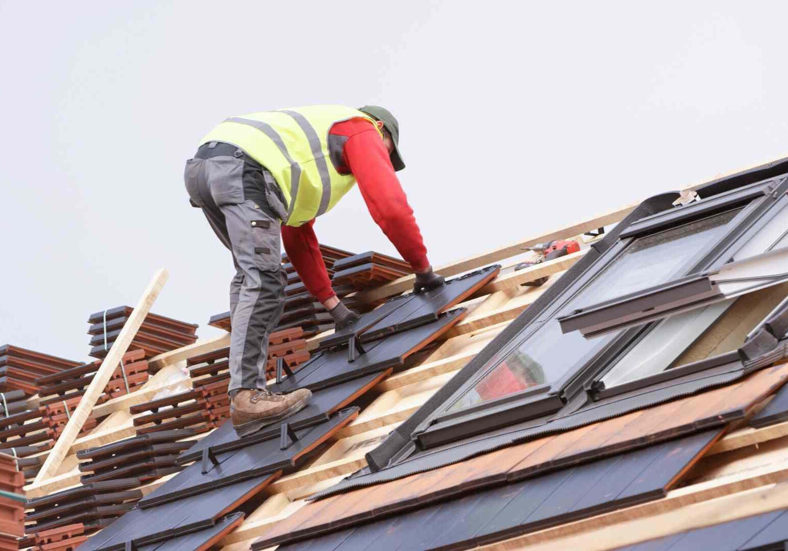 A man working on the roof of a house.