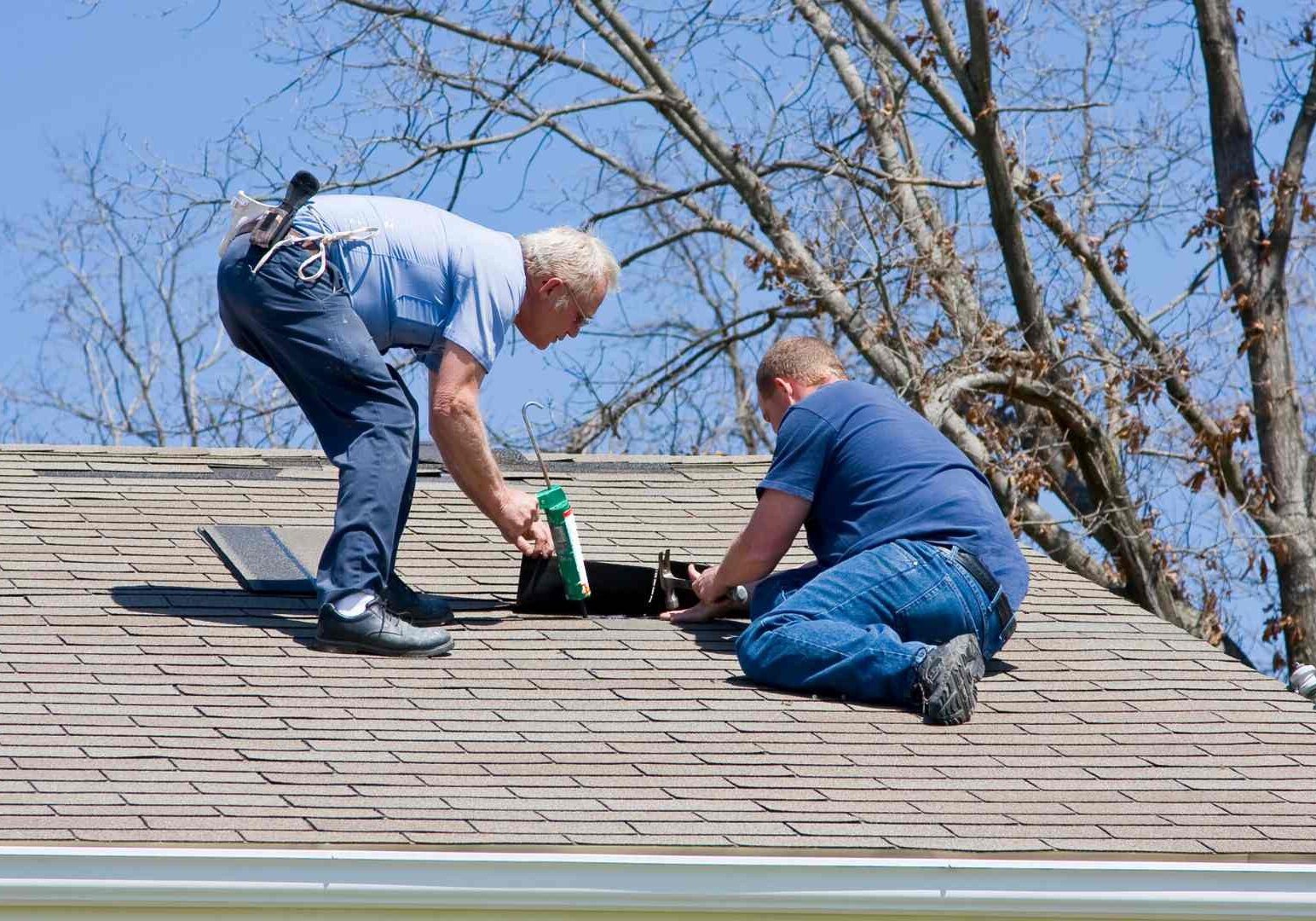 Two men working on a roof top.